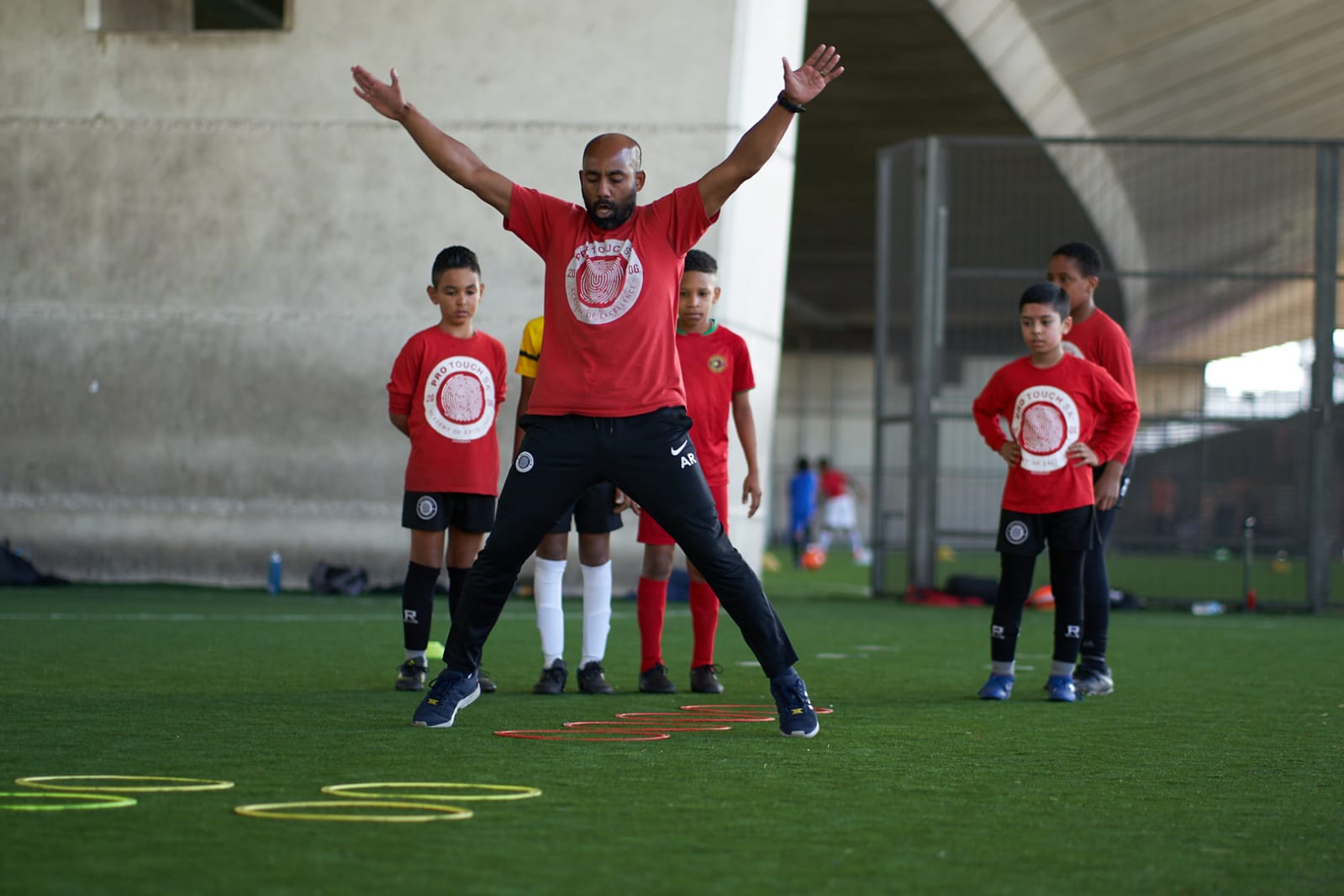 Ash Rahman leading a warm-up with a group of young players